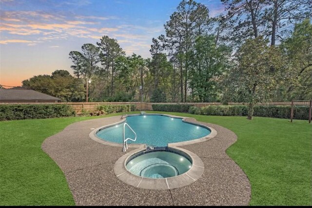 11219 Lorton Dr, Houston, TX 77070 - pool at dusk with an in-ground hot tub and view of wooded area