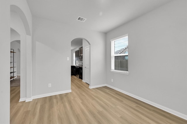 22807 Gentle Shadow Dr, Hockley, TX 77447 - unfurnished room featuring light wood-style flooring, baseboards, and arched walkways