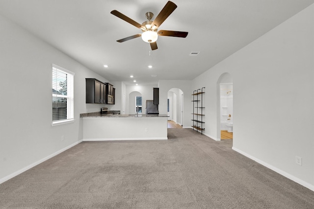 22807 Gentle Shadow Dr, Hockley, TX 77447 - unfurnished living room with arched walkways, a ceiling fan, light colored carpet, baseboards, and recessed lighting