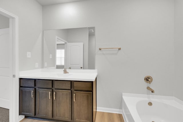 22807 Gentle Shadow Dr, Hockley, TX 77447 - bathroom featuring vanity, a garden tub, wood finished floors, and baseboards