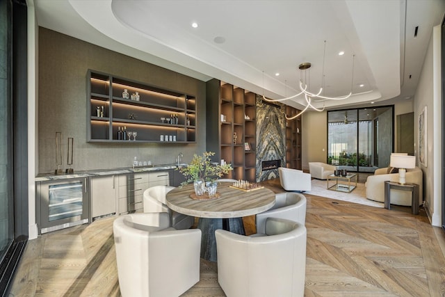 9010 Memorial Dr, Houston, TX 77024 - indoor wet bar with wine cooler, a tray ceiling, a chandelier, recessed lighting, and built in features