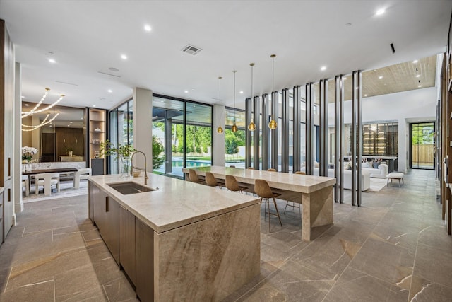 9010 Memorial Dr, Houston, TX 77024 - kitchen with a sink, modern cabinets, a spacious island, plenty of natural light, and a towering ceiling