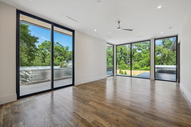 9010 Memorial Dr, Houston, TX 77024 - unfurnished room with expansive windows, plenty of natural light, ceiling fan, wood finished floors, and baseboards