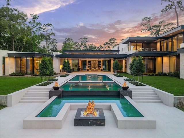 9010 Memorial Dr, Houston, TX 77024 - rear view of house featuring a fire pit, stairway, an outdoor pool, a lawn, and an in-ground hot tub