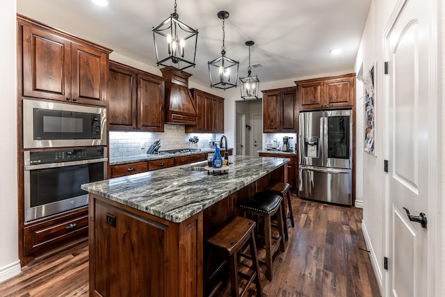 1812 Camellia Dr, Huntsville, TX 77340 - kitchen featuring appliances with stainless steel finishes, premium range hood, a chandelier, a breakfast bar area, and backsplash