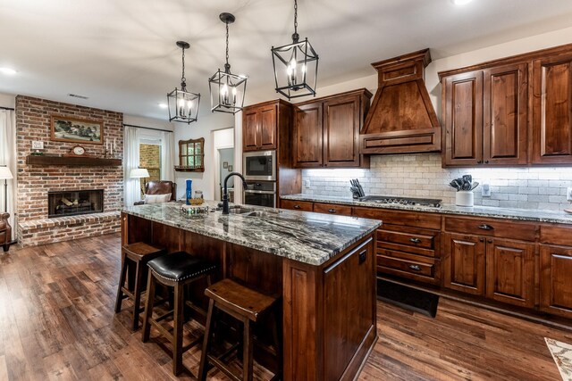 1812 Camellia Dr, Huntsville, TX 77340 - kitchen featuring stainless steel appliances, premium range hood, stone counters, dark wood finished floors, and recessed lighting