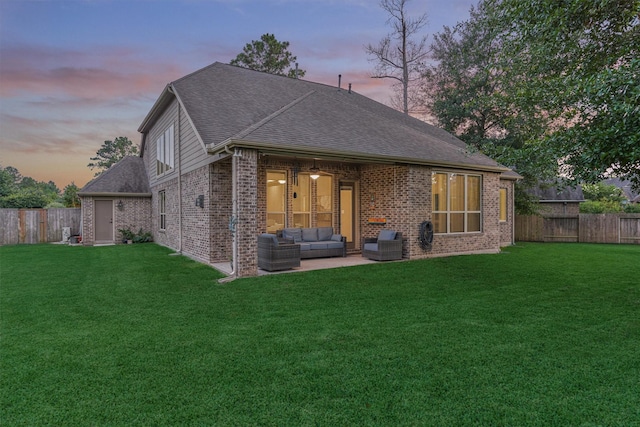 114 Cedar Brush Ct, Montgomery, TX 77316 - back of property at dusk with an outdoor hangout area, a patio area, brick siding, and a shingled roof