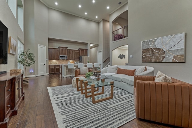 114 Cedar Brush Ct, Montgomery, TX 77316 - living area with dark wood-type flooring, a high ceiling, arched walkways, recessed lighting, and baseboards
