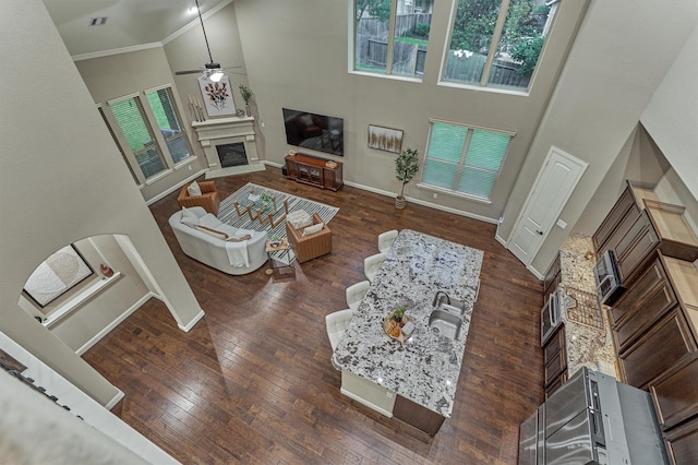 114 Cedar Brush Ct, Montgomery, TX 77316 - living room with a towering ceiling, a fireplace, a ceiling fan, baseboards, and hardwood / wood-style floors