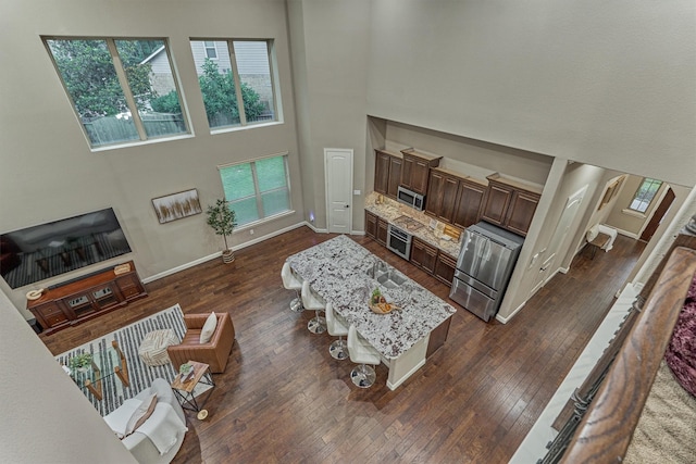 114 Cedar Brush Ct, Montgomery, TX 77316 - living area with a high ceiling, dark wood-style floors, and baseboards