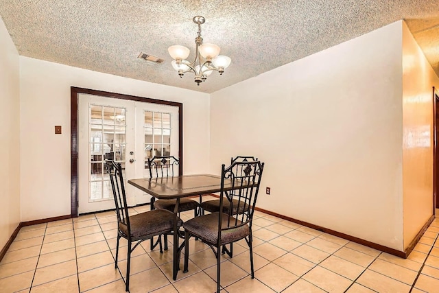 170 Trails End Dr, Cleveland, TX 77328 - dining space featuring a chandelier, light tile patterned floors, french doors, and a textured ceiling