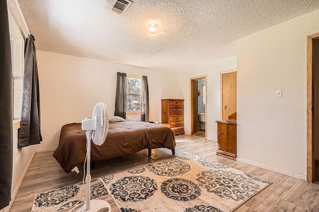 170 Trails End Dr, Cleveland, TX 77328 - bedroom featuring a textured ceiling and light wood-style flooring