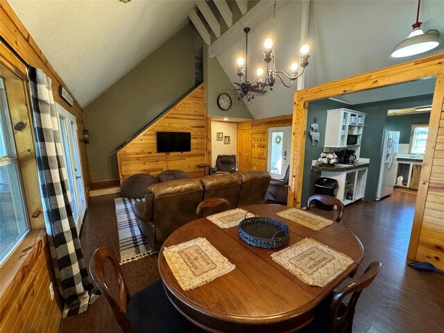 164 Pine Hollow Cv, Brookeland, TX 75931 - dining room with wood walls, wood finished floors, a chandelier, baseboards, and high vaulted ceiling