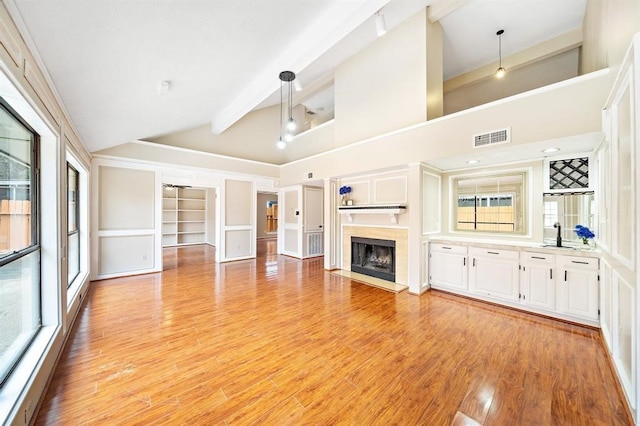 21102 Marcin Dr, Spring, TX 77388 - unfurnished living room with built in features, light wood-style flooring, a high end fireplace, high vaulted ceiling, and beamed ceiling