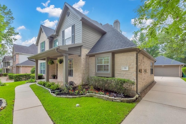 126 S Bluff Creek Cir, The Woodlands, TX 77382 - traditional-style house with a chimney, stone siding, a detached garage, a front yard, and a shingled roof