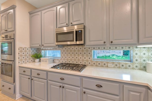 126 S Bluff Creek Cir, The Woodlands, TX 77382 - kitchen featuring stainless steel appliances, light countertops, and gray cabinetry