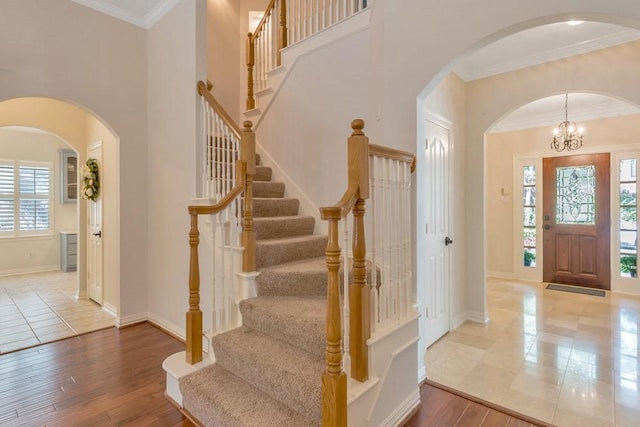 126 S Bluff Creek Cir, The Woodlands, TX 77382 - entrance foyer with stairway, crown molding, wood finished floors, arched walkways, and a chandelier