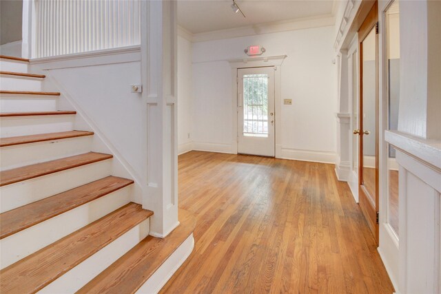 239 Westheimer Rd, Houston, TX 77006 - entrance foyer featuring light wood-type flooring, stairway, crown molding, baseboards, and rail lighting