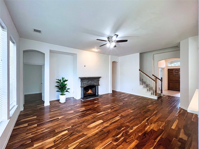 3822 Breckenridge Dr Unit X77356, Montgomery, TX 77356 - unfurnished living room featuring arched walkways, wood finished floors, a lit fireplace, a ceiling fan, and healthy amount of natural light