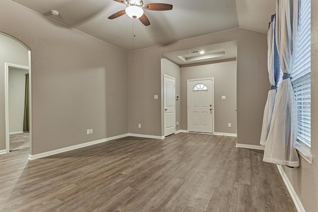 14208 Sedona Ridge Dr, Conroe, TX 77303 - foyer featuring wood finished floors, ceiling fan, arched walkways, and a tray ceiling