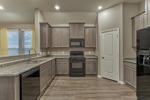 14208 Sedona Ridge Dr, Conroe, TX 77303 - kitchen featuring black appliances, light wood-type flooring, light stone countertops, and recessed lighting