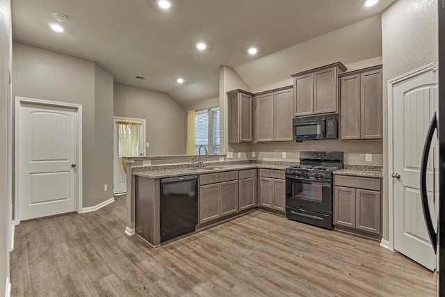 14208 Sedona Ridge Dr, Conroe, TX 77303 - kitchen with black appliances, light wood-style flooring, vaulted ceiling, a peninsula, and recessed lighting
