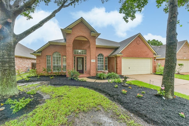 11510 Amber Canyon Dr, Houston, TX 77095 - traditional-style house with brick siding, an attached garage, concrete driveway, and a shingled roof