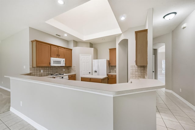 11510 Amber Canyon Dr, Houston, TX 77095 - kitchen with white appliances, light tile patterned floors, arched walkways, backsplash, and light countertops