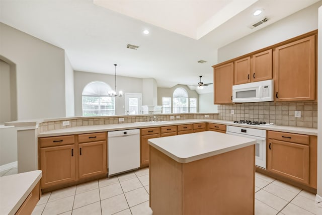 11510 Amber Canyon Dr, Houston, TX 77095 - kitchen with white appliances, a peninsula, decorative backsplash, light countertops, and light tile patterned floors
