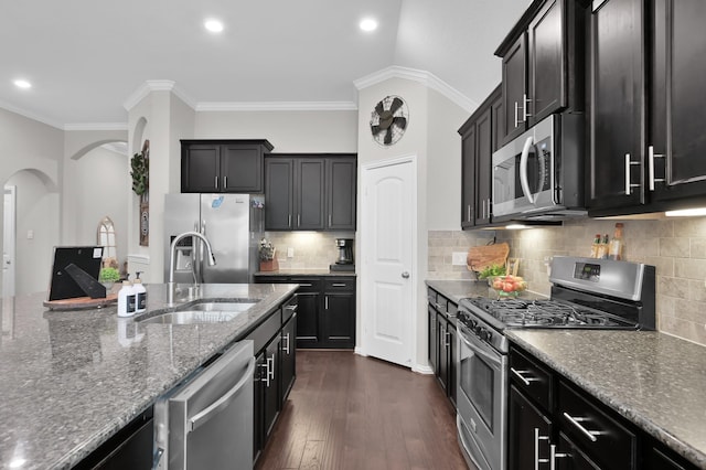 138 Verismo Ct, Montgomery, TX 77316 - kitchen featuring appliances with stainless steel finishes, arched walkways, dark stone countertops, recessed lighting, and crown molding