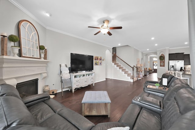 138 Verismo Ct, Montgomery, TX 77316 - living area with arched walkways, ceiling fan, wood finished floors, crown molding, and stairway