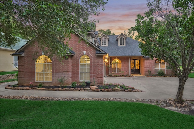 16 Waterberry Way, Montgomery, TX 77356 - traditional-style house featuring brick siding, a front lawn, driveway, and a shingled roof