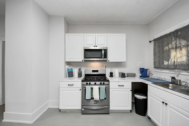 4409 Brady St, Houston, TX 77011 - kitchen featuring appliances with stainless steel finishes, white cabinetry, and light countertops