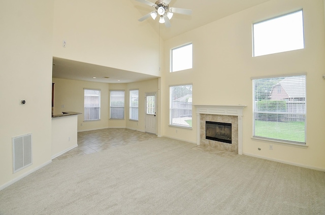 25314 Sandy Trace Ln, Katy, TX 77494 - unfurnished living room featuring light colored carpet, a towering ceiling, ceiling fan, a tiled fireplace, and light tile patterned floors