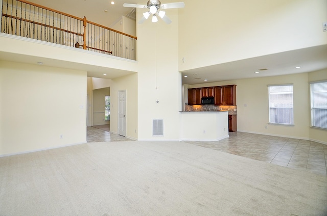 25314 Sandy Trace Ln, Katy, TX 77494 - unfurnished living room with light colored carpet, light tile patterned floors, a ceiling fan, a high ceiling, and recessed lighting