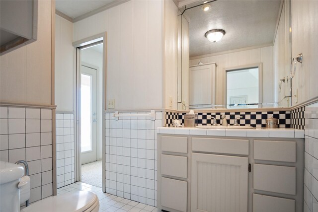 3101 Diane, Crystal Beach, TX 77650 - bathroom with toilet, tile walls, crown molding, tile patterned flooring, and vanity