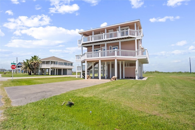 3101 Diane, Crystal Beach, TX 77650 - rear view of house featuring concrete driveway, a carport, and a lawn