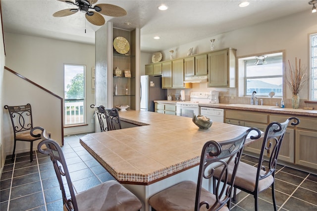 3101 Diane, Crystal Beach, TX 77650 - kitchen featuring tile countertops, white appliances, under cabinet range hood, a sink, and recessed lighting