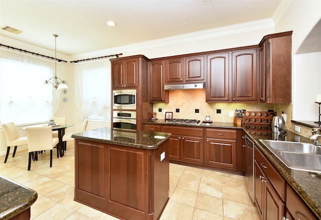 1226 Sopris Dr, Houston, TX 77077 - kitchen featuring appliances with stainless steel finishes, a sink, under cabinet range hood, decorative light fixtures, and ornamental molding