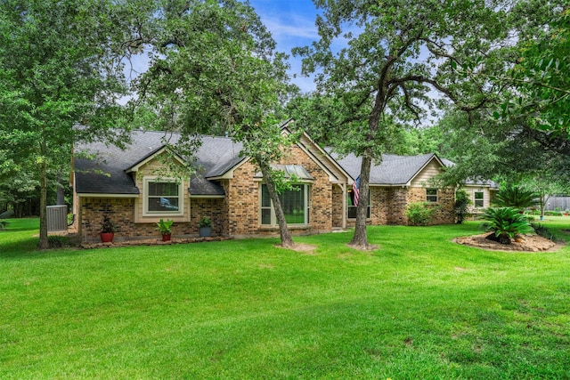33315 Cripple Creek Dr, Pinehurst, TX 77362 - ranch-style home featuring a front lawn, roof with shingles, and brick siding