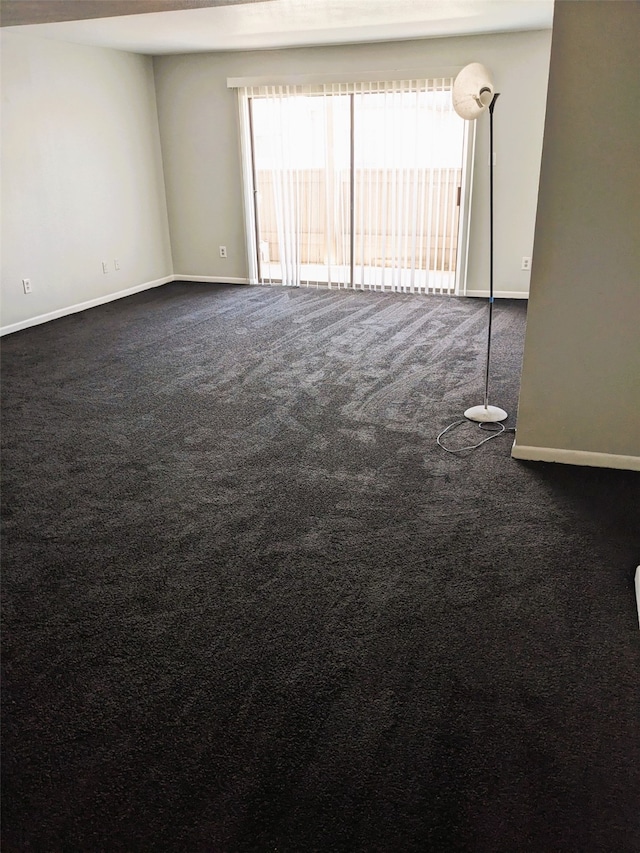 8421 Hearth Dr Unit 21, Houston, TX 77054 - empty room featuring healthy amount of natural light, dark carpet, and baseboards