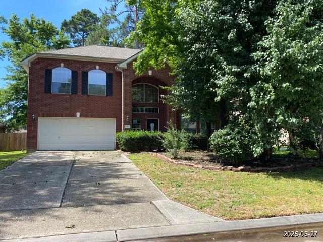 151 Prairie Dawn Cir, Conroe, TX 77385 - view of front of home with a garage, brick siding, and concrete driveway