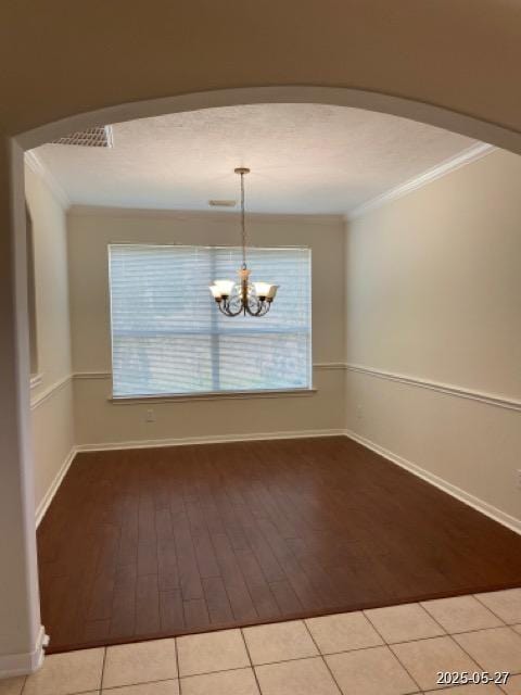 151 Prairie Dawn Cir, Conroe, TX 77385 - unfurnished dining area featuring crown molding, wood finished floors, arched walkways, a chandelier, and baseboards