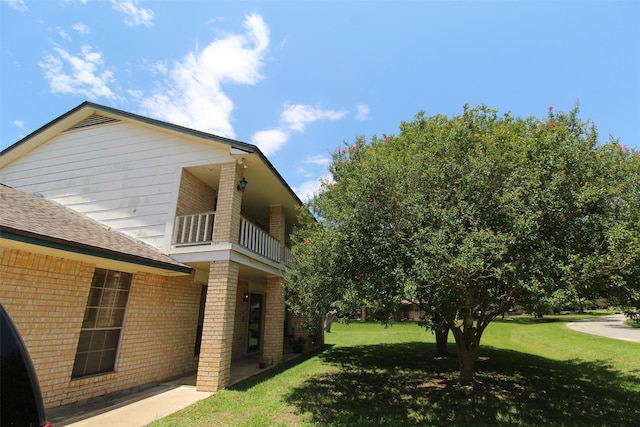 32226 Divot Dr, Waller, TX 77484 - view of home's exterior with brick siding, a balcony, a lawn, and roof with shingles