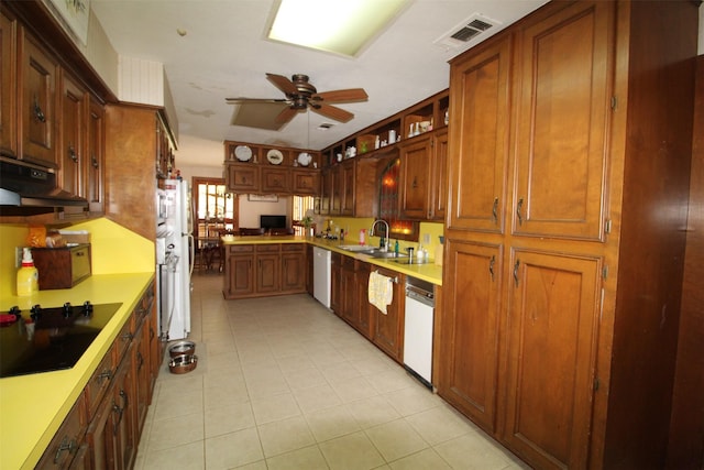 32226 Divot Dr, Waller, TX 77484 - kitchen with black electric stovetop, under cabinet range hood, dishwasher, ceiling fan, and light tile patterned flooring
