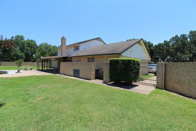 32226 Divot Dr, Waller, TX 77484 - view of side of home with a gate, a patio, a chimney, and brick siding