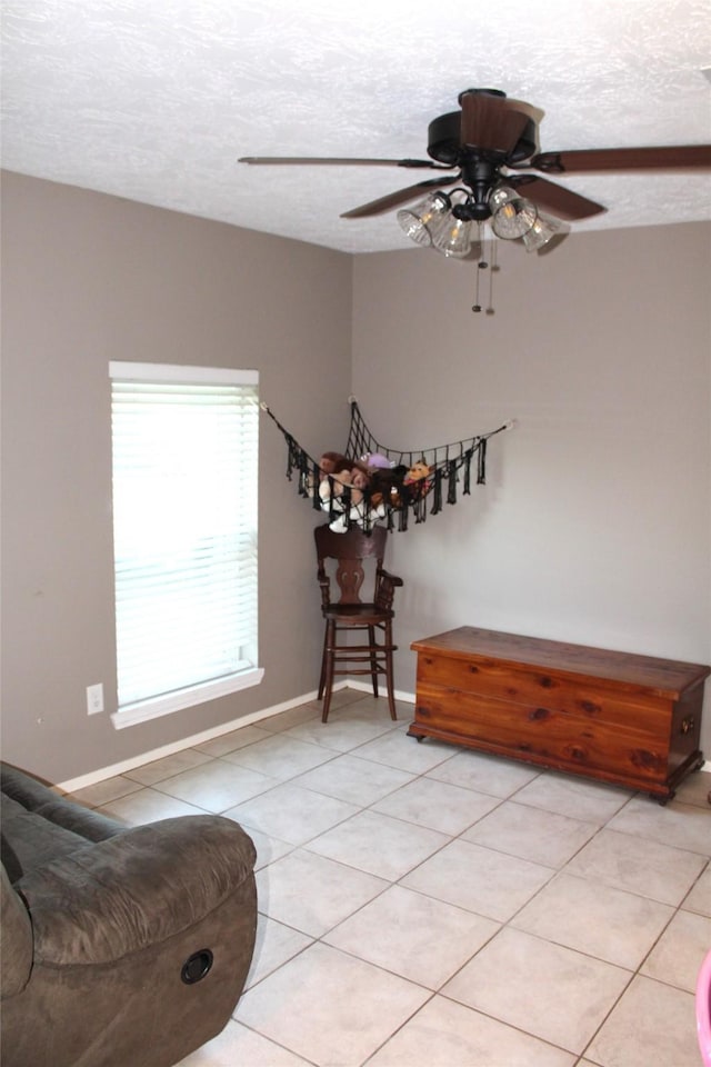 9807 Sparrow St, La Porte, TX 77571 - living area featuring light tile patterned floors, a ceiling fan, a textured ceiling, and baseboards