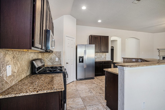 6843 Oaken Gate Way, Humble, TX 77338 - kitchen featuring stainless steel appliances, arched walkways, dark brown cabinets, backsplash, and recessed lighting