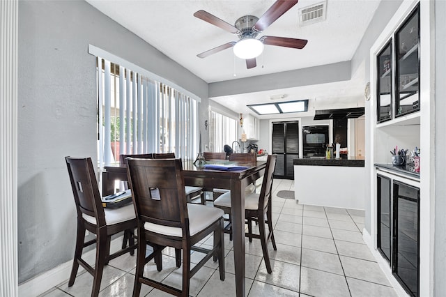 11703 Teaneck Dr, Houston, TX 77089 - dining area featuring ceiling fan, light tile patterned floors, baseboards, and beverage cooler