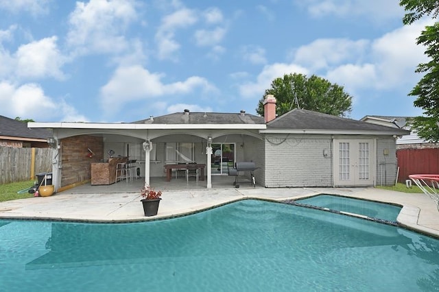 11703 Teaneck Dr, Houston, TX 77089 - back of property with french doors, a patio, brick siding, and a pool with connected hot tub